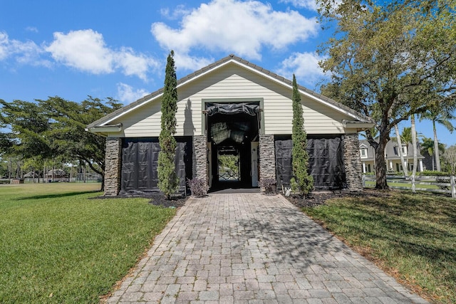 exterior space featuring stone siding and a front yard