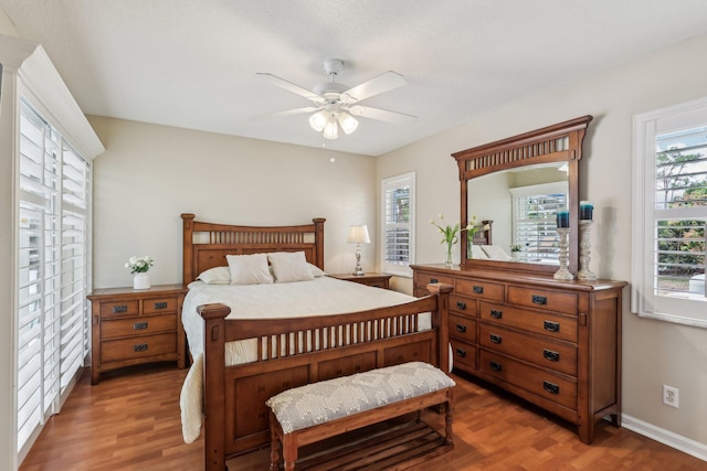 bedroom with ceiling fan, baseboards, and wood finished floors