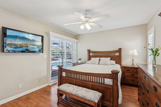 bedroom featuring access to exterior, multiple windows, and wood finished floors