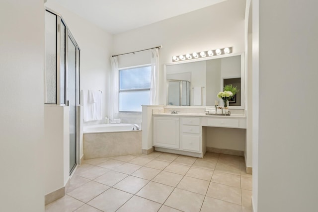 bathroom featuring tile patterned floors, a stall shower, vanity, baseboards, and a bath