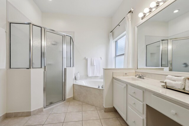 full bath with a stall shower, a garden tub, vanity, and tile patterned floors