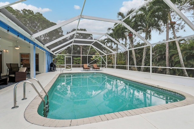 pool with ceiling fan, a patio, and glass enclosure