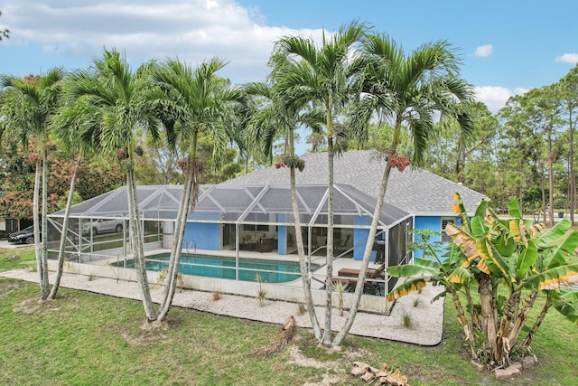 pool featuring glass enclosure and a patio area