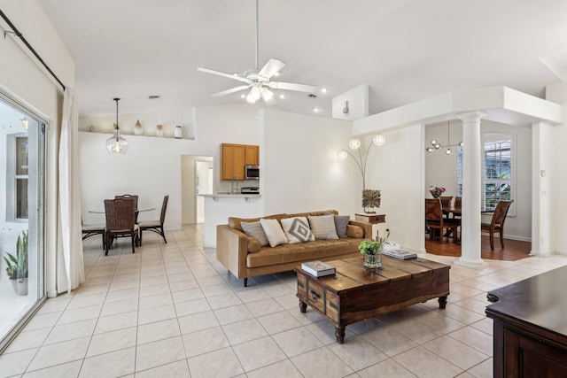 living room featuring ornate columns, vaulted ceiling, a ceiling fan, and light tile patterned flooring