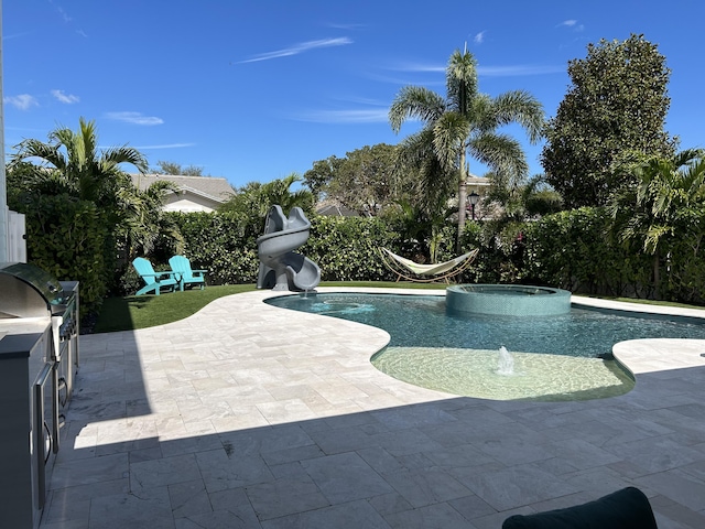 view of swimming pool with a patio area, a pool with connected hot tub, a water slide, and area for grilling