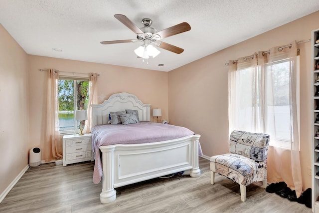 bedroom featuring ceiling fan, baseboards, and wood finished floors