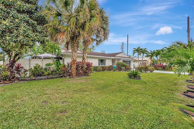 view of yard featuring a garage and fence