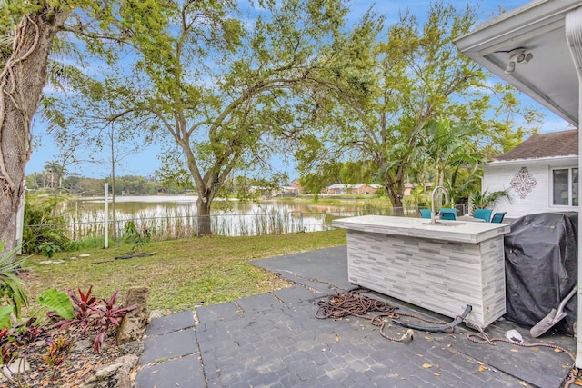 view of yard with a patio area, fence, and a water view