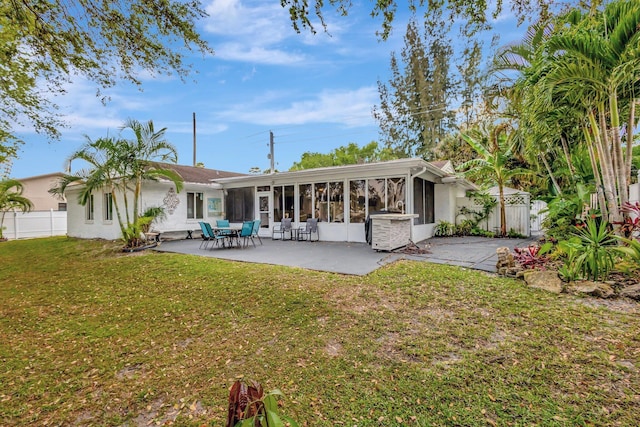 back of house featuring a yard, a patio area, fence, and a sunroom