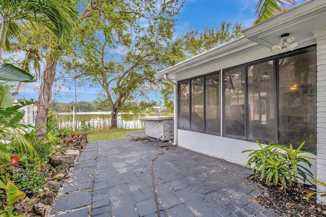 view of patio / terrace with a sunroom and a water view