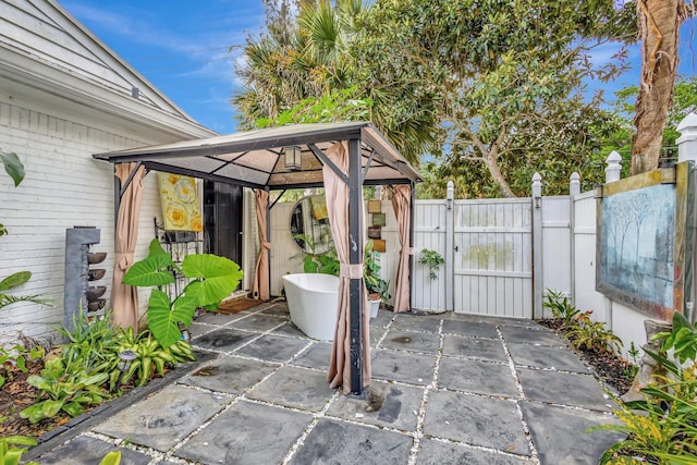 view of patio / terrace with a gate, fence, and a gazebo