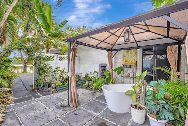 view of patio featuring fence and a gazebo