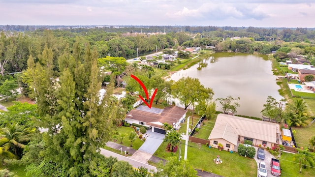 birds eye view of property featuring a water view and a wooded view