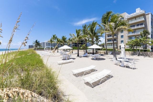 surrounding community with a water view and a view of the beach