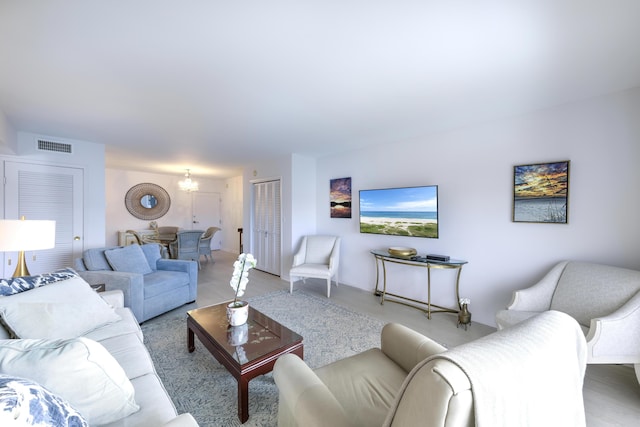 living area featuring visible vents and a notable chandelier