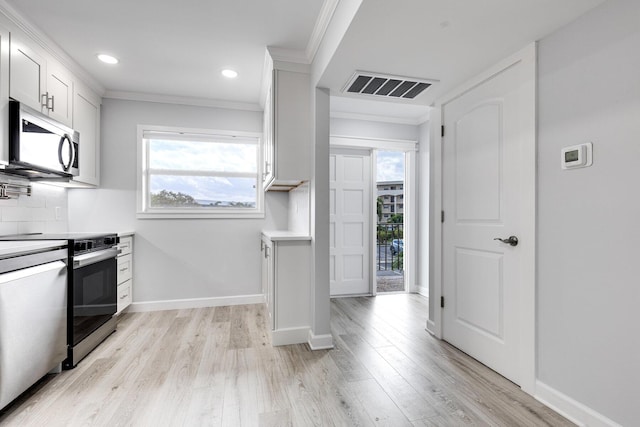 kitchen with light wood-style flooring, stainless steel appliances, visible vents, decorative backsplash, and crown molding