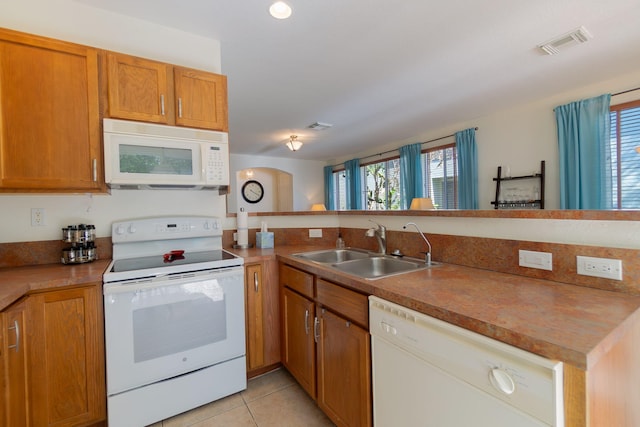 kitchen with visible vents, a healthy amount of sunlight, white appliances, and a sink