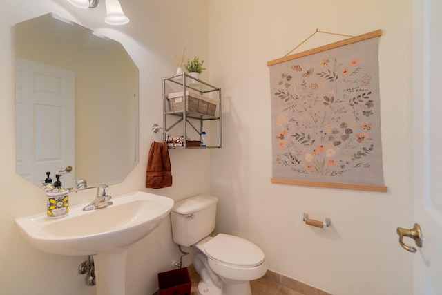 half bathroom featuring tile patterned flooring and toilet