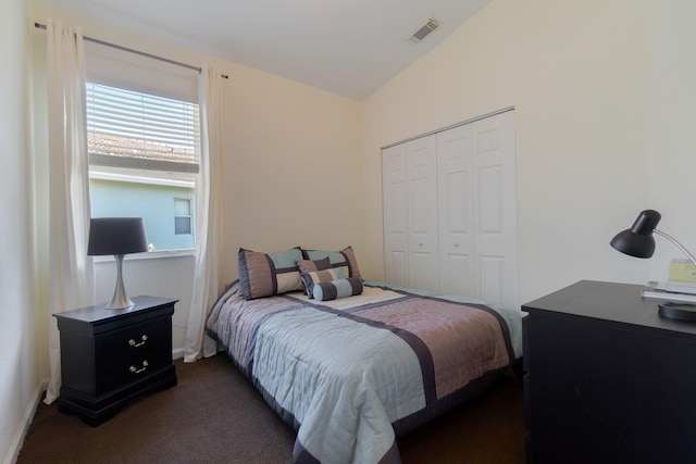 carpeted bedroom featuring visible vents and a closet