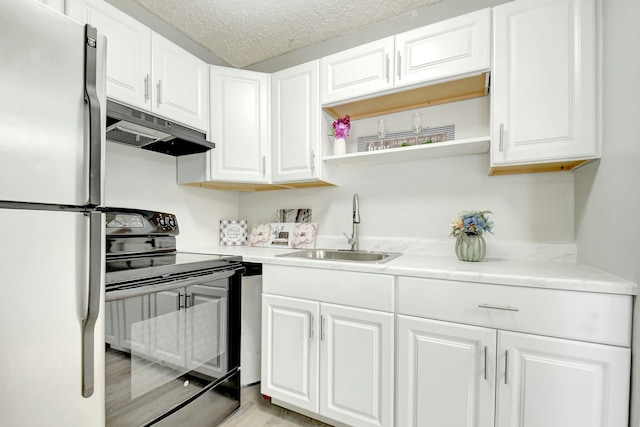 kitchen with black electric range oven, freestanding refrigerator, white cabinets, a sink, and under cabinet range hood