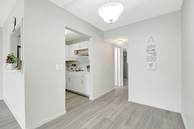 hall with light wood finished floors and baseboards