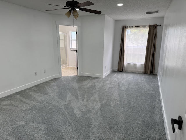 carpeted spare room with a textured ceiling, ceiling fan, recessed lighting, visible vents, and baseboards