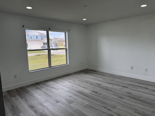 unfurnished room featuring recessed lighting, baseboards, and wood finished floors