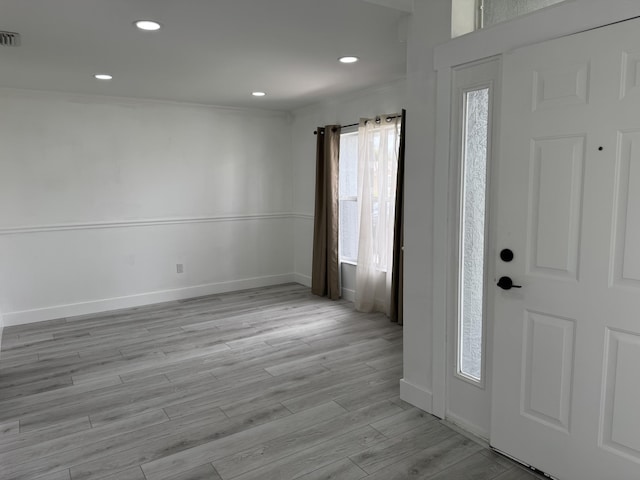 entrance foyer featuring baseboards, light wood finished floors, recessed lighting, and crown molding