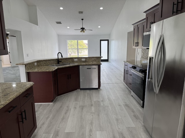 kitchen featuring visible vents, a ceiling fan, light wood-style flooring, appliances with stainless steel finishes, and a sink