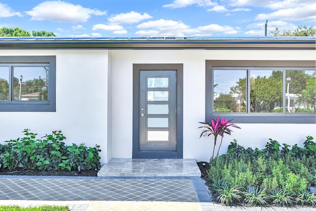 view of exterior entry featuring stucco siding