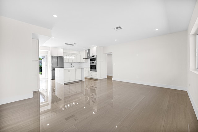 unfurnished living room with recessed lighting, baseboards, visible vents, and a sink