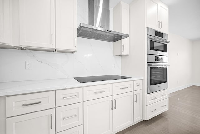 kitchen featuring decorative backsplash, white cabinetry, double oven, wall chimney exhaust hood, and black electric cooktop