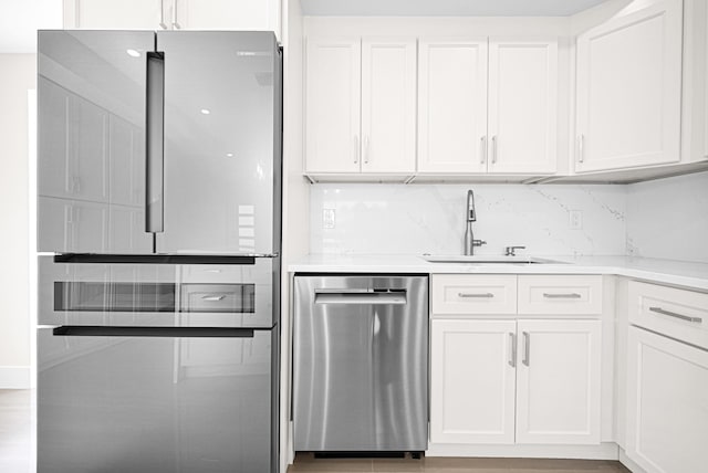 kitchen featuring a sink, stainless steel appliances, white cabinets, and light countertops