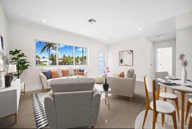 living area featuring visible vents, recessed lighting, baseboards, and wood finished floors