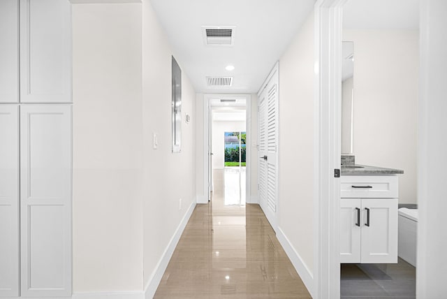 hall with visible vents and baseboards