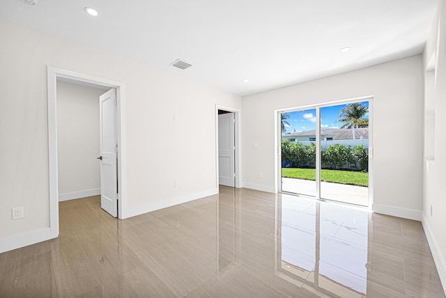 spare room with recessed lighting, visible vents, and baseboards