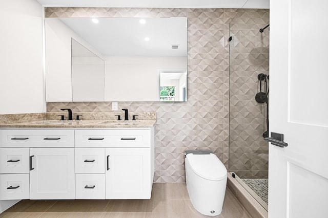 bathroom with a tile shower, toilet, and a sink