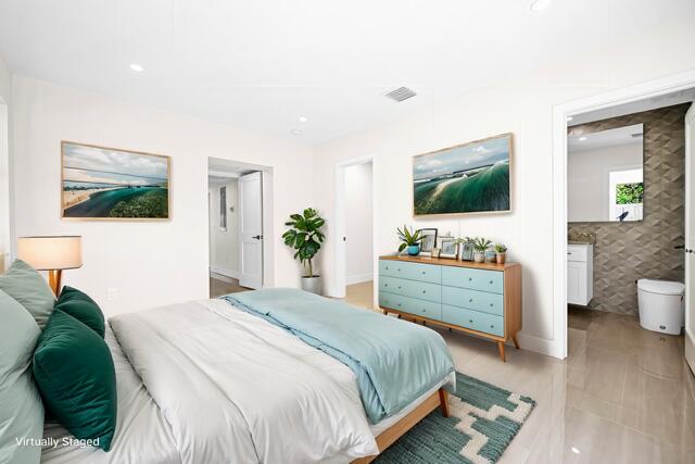 bedroom with ensuite bath, tile walls, recessed lighting, and visible vents