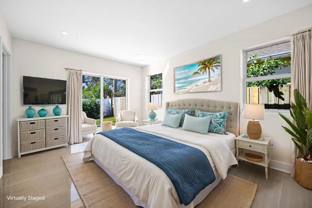 bedroom with access to outside, multiple windows, recessed lighting, and light wood finished floors