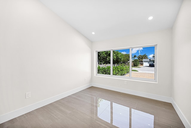 spare room with vaulted ceiling, recessed lighting, and baseboards