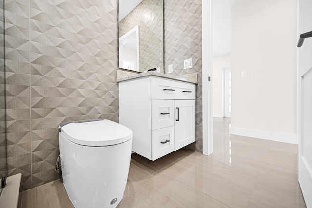 bathroom with toilet, tile walls, and vanity