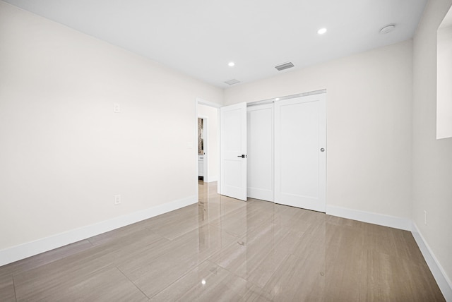 unfurnished bedroom with recessed lighting, visible vents, baseboards, and a closet