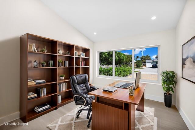 office area featuring light wood finished floors, recessed lighting, baseboards, and lofted ceiling