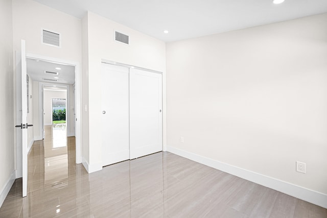 unfurnished bedroom featuring recessed lighting, baseboards, visible vents, and a closet