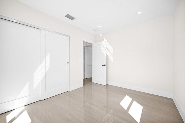 unfurnished bedroom featuring a closet, visible vents, recessed lighting, and baseboards