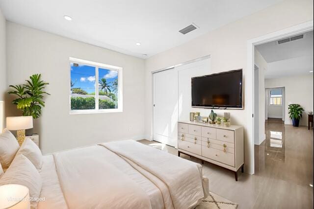 bedroom with light wood-type flooring, visible vents, and recessed lighting