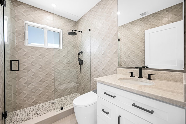 bathroom featuring vanity, a shower stall, toilet, and visible vents