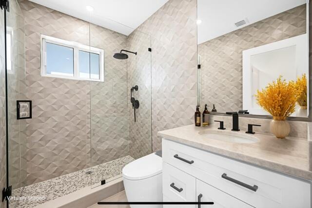 bathroom featuring visible vents, vanity, toilet, and a shower stall