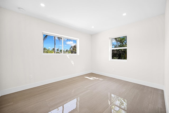 spare room with a wealth of natural light, recessed lighting, and baseboards