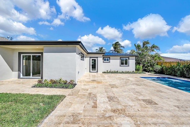 back of property with stucco siding, fence, and a patio area